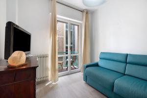 ein Wohnzimmer mit einem blauen Sofa und einem TV in der Unterkunft Perla di Finale in Finale Ligure