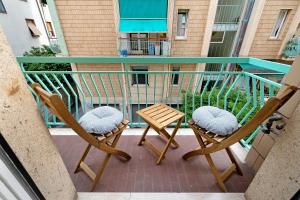 dwa krzesła i stół na balkonie w obiekcie Perla di Finale w mieście Finale Ligure