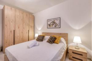 a bedroom with a large bed with a wooden headboard at Pool Apartment-Hosted by Sweetstay in Is-Swieqi