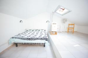 a white room with a bed and a chair at Casa Pamalù in Nisporto