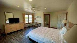 a bedroom with a bed and a flat screen tv at Pony Island Inn in Ocracoke