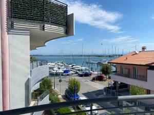 a balcony with a view of a marina with boats at Costa Azzurra Aparment in Grado