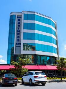 two cars parked in front of a building at Brand Business Hotel in Corlu