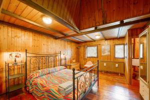 a bedroom with a bed in a room with wooden walls at Casa Jonathan in Saint Vincent