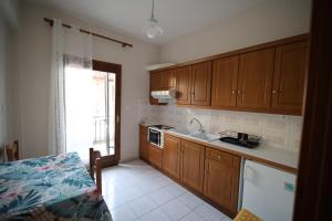 a kitchen with wooden cabinets and a sink at Island Boutique Apartments in Pyrgadikia
