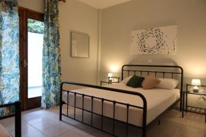 1 dormitorio con cama y ventana en Island Boutique Apartments, en Pyrgadikia