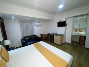 ein Hotelzimmer mit einem großen Bett und einem Tisch in der Unterkunft Hotel Vicentina in Boca Chica