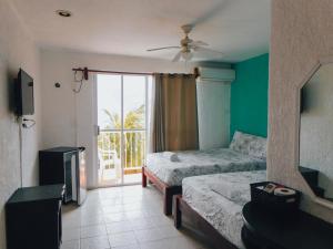 a hotel room with two beds and a balcony at Hotel Ma Elena in Isla Mujeres