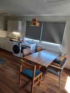 cocina con mesa de madera y sillas en una habitación en Vinland Apartment 2, en Egilsstadir