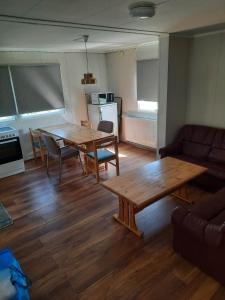 - un salon avec une table, des chaises et un canapé dans l'établissement Vinland Apartment 2, à Egilsstaðir