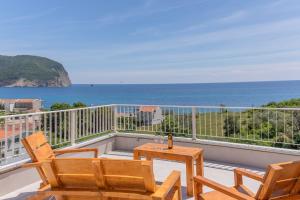a balcony with chairs and a table and the ocean at Apartments Bonazza in Petrovac na Moru