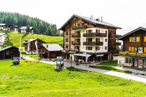 eine Gruppe von Gebäuden auf einem Hügel mit einer Stadt in der Unterkunft Haus Sportina in Riederalp