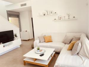 sala de estar con sofá blanco y TV en 3091 Villa MALIBU, en Orihuela