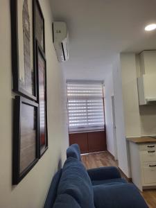 ein blaues Sofa im Wohnzimmer mit Fenster in der Unterkunft Apartamento Parque Bahía in Puerto Real