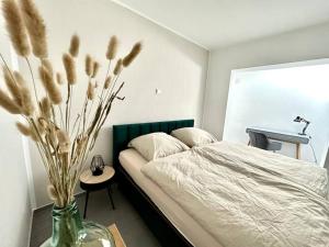 a bedroom with a bed and a vase with flowers at Ferienwohnung komfortabel Wohnen Bremerhaven in Bremerhaven