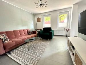 un soggiorno con divano rosso e sedia verde di Ferienwohnung komfortabel Wohnen Bremerhaven a Bremerhaven