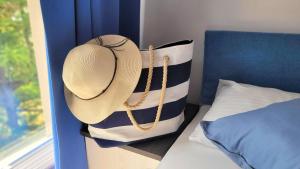 un cappello di paglia poggiato su un cuscino su un letto di Apartamenty Lambert Ustronie Morskie a Ustronie Morskie