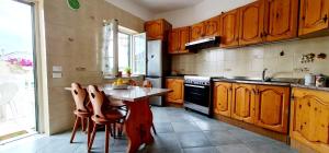 una cocina con armarios de madera y una mesa con sillas. en Torrione Maison en Ischia