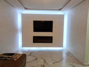 a living room with a television on a wall at Apartment 3 kamers Nador Jadid Hay Al Matar appart 006 in Nador +8 photos