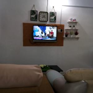 a living room with a couch and a flat screen tv at Rumah Tamu FieSari Jeli M U S L I M in Jeli