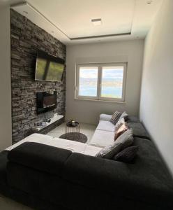 een slaapkamer met een groot bed en een bakstenen muur bij Seaesta holiday-Luxury seaview in Trogir