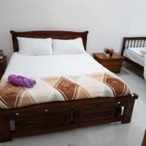 una cama con un animal de peluche púrpura sentado en ella en Rumah Tamu FieSari Jeli M U S L I M en Jeli
