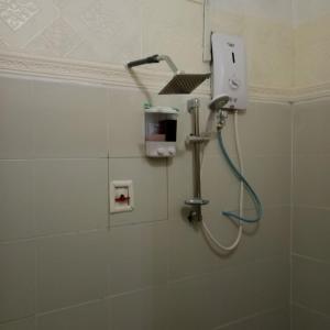 y baño con ducha y cabezal de ducha. en Rumah Tamu FieSari Jeli M U S L I M en Jeli