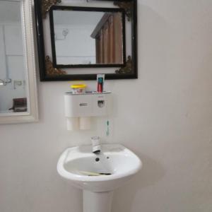 a white sink in a bathroom with a mirror at Rumah Tamu FieSari Jeli M U S L I M in Jeli
