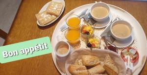 una mesa con un plato de desayuno y tazas de café en Chambre Maddy, en Parranquet