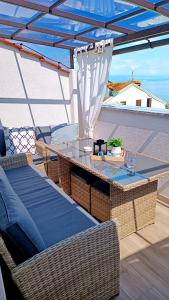 a patio with a table and chairs under a blue umbrella at Apartman Leona in Lovran
