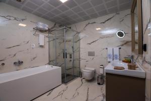 y baño con bañera, aseo y lavamanos. en Brand Business Hotel en Corlu
