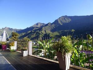 a balcony with potted plants and mountains in the background at Villa VETYVER de CILAOS in Cilaos