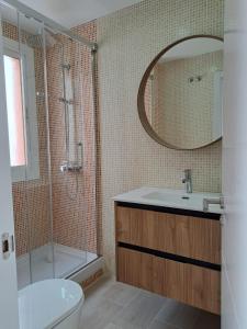 Un baño con lavabo, inodoro y espejo. en El lugar ideal, en Vera