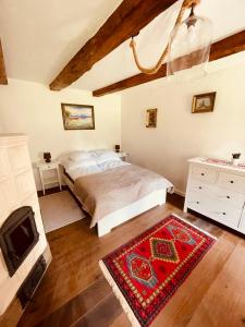 a bedroom with a bed and a tv and a rug at A Házikó - Cottage in Vonyarcvashegy