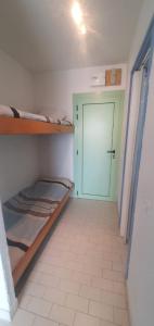 a room with two bunk beds and a green door at Très joli studio 4 personnes avec terrasse front de mer in Leucate