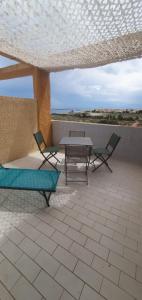 a patio with two chairs and a table on a roof at Très joli studio 4 personnes avec terrasse front de mer in Leucate