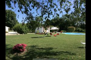 SonnacにあるLe Clos du Plantisのプール、テーブル、椅子が備わる庭園