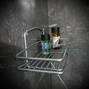a metal rack with two bottles on a wall at Centrally Apartments in Xanthi