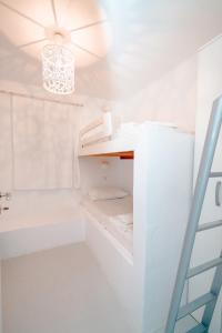 a white bathroom with a chandelier and a white tub at Villa Agia Irene Kythnos in Kithnos