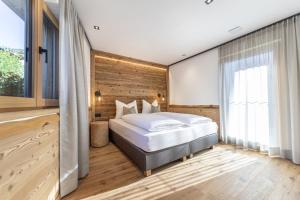 a bedroom with a bed and a wooden wall at Chalet Berna in Ortisei