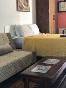 聖文森特的住宿－Palladium Apart Service，客房设有两张床、一张沙发和一张桌子。