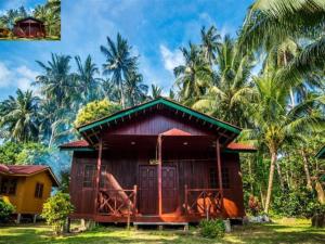 una pequeña casa frente a unas palmeras en Juara Beach Resort, en Tioman Island