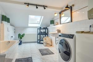 ein Badezimmer mit einer Waschmaschine und einem Waschbecken in der Unterkunft Residenz unter den Linden Falke in Mühlhausen