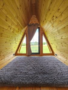 a bedroom with a large window in a wooden room at LOGIS LAS CROZAS La Cocotte in Vernines