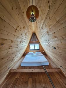 a room with a bed in a wooden cabin at LOGIS LAS CROZAS La Cocotte in Vernines