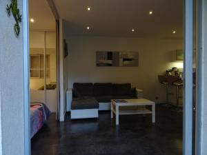 uma sala de estar com um sofá e uma mesa em Appartement avec jardin et parking em Cassis