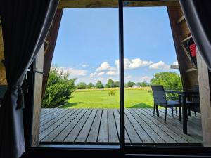 an open door to a deck with a table and a chair at LOGIS LAS CROZAS La Cocotte in Vernines