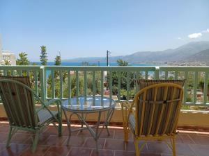 a patio with two chairs and a glass table on a balcony at Primavera Suite in Stalís