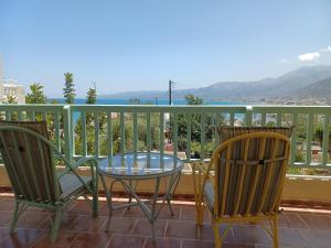 a patio with two chairs and a glass table on a balcony at Primavera Suite in Stalida