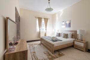 Un dormitorio blanco con una cama y una mesa. en HiGuests - Cheerful Apt With Stunning Views in Port Saeed, en Dubái